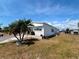 Exterior side view of a well-maintained house with mature palm trees and lawn at 237 Blackburn Blvd, North Port, FL 34287