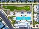 Aerial view of community amenities featuring a pool and putting green surrounded by blue and white townhomes at 2408 Ezzell Ct, Sarasota, FL 34237