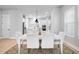 Dining area and kitchen featuring white cabinets, stainless steel appliances, and modern lighting at 2408 Ezzell Ct, Sarasota, FL 34237