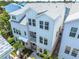 Stunning three-story white townhome with a balcony and lush landscaping, offering luxurious curb appeal at 2408 Ezzell Ct, Sarasota, FL 34237