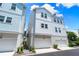 Rear elevation of townhome with a two-car garage and white siding at 2408 Ezzell Ct, Sarasota, FL 34237