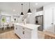 Open-concept kitchen with white island, stainless steel refrigerator, and seamless flow into the dining area at 2408 Ezzell Ct, Sarasota, FL 34237