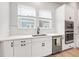Bright kitchen featuring white cabinetry, stainless steel appliances, and stylish tile backsplash at 2408 Ezzell Ct, Sarasota, FL 34237