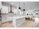 Open concept kitchen with island, pendant lights, and stainless appliances flowing into the dining and living area at 2408 Ezzell Ct, Sarasota, FL 34237