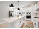 Modern kitchen with white cabinets, stainless steel appliances, and a large center island with pendant lighting at 2408 Ezzell Ct, Sarasota, FL 34237