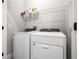 Laundry room with white washer and dryer and overhead storage at 2408 Ezzell Ct, Sarasota, FL 34237