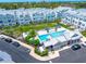 Aerial view of a community pool surrounded by stylish townhomes, lounge chairs and lush landscaping at 2408 Ezzell Ct, Sarasota, FL 34237