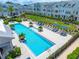Stunning aerial view of a sparkling community pool featuring lounge chairs, palm trees, and modern townhomes at 2408 Ezzell Ct, Sarasota, FL 34237
