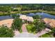 Stunning aerial view of waterfront home with brick driveway, lush landscaping, and private pool at 2496 Farms Ct, Sarasota, FL 34240