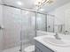 Modern bathroom with a glass-enclosed shower, gray vanity, and neutral tile at 2496 Farms Ct, Sarasota, FL 34240