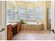 Bright bathroom with a soaking tub, dual sinks, and a glass-enclosed shower at 2496 Farms Ct, Sarasota, FL 34240