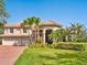 Well-maintained two-story home with a three-car garage and lush landscaping at 2496 Farms Ct, Sarasota, FL 34240