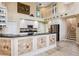 Modern kitchen with white cabinets, black countertops, and a stainless steel refrigerator, complemented by a soaring ceiling at 2496 Farms Ct, Sarasota, FL 34240
