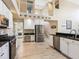 Updated kitchen features stainless steel appliances, white cabinetry, and a view towards the laundry room and staircase at 2496 Farms Ct, Sarasota, FL 34240