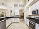 Open kitchen showcasing granite counters, white cabinets, and an easy flow into adjacent dining and living areas at 2496 Farms Ct, Sarasota, FL 34240