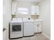 Functional laundry room with washer, dryer, sink, and storage cabinets at 2496 Farms Ct, Sarasota, FL 34240