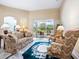Cozy living room with plush seating, a ceiling fan, and sliding glass doors at 2496 Farms Ct, Sarasota, FL 34240