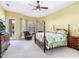 Bright main bedroom with a floral-patterned bed, an ornate dresser, and access to the outdoor balcony at 2496 Farms Ct, Sarasota, FL 34240