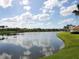 Scenic view of the pond with blue skies and green lawn at 2496 Farms Ct, Sarasota, FL 34240