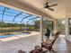 Screened-in patio with wicker chairs overlooking the pool and lake in the background at 2496 Farms Ct, Sarasota, FL 34240