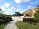 Relaxing pool area with a paved walkway surrounded by tropical landscaping and a glimpse of the lake at 2496 Farms Ct, Sarasota, FL 34240