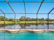 Backyard pool with beautiful water view framed by a screen enclosure at 2496 Farms Ct, Sarasota, FL 34240