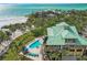 Aerial view of a home with a pool, spa, and beach access overlooking the ocean at 26 Sandy Hook S Rd, Sarasota, FL 34242