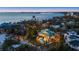Coastal home aerial view shows a beachfront property with lush landscaping, pool, and nearby cityscape at 26 Sandy Hook S Rd, Sarasota, FL 34242