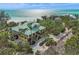 Stunning aerial view of a coastal home with lush landscaping and ocean views at 26 Sandy Hook S Rd, Sarasota, FL 34242