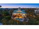 Aerial night view of a luxury home with a pool, spa, and beautifully lit landscaping at 26 Sandy Hook S Rd, Sarasota, FL 34242