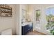 Charming powder room featuring a stylish vanity, decorative mirror, and a door opening to the outside at 26 Sandy Hook S Rd, Sarasota, FL 34242