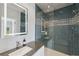 Modern bathroom featuring stylish blue tiling and a glass-enclosed shower with decorative tile accents at 26 Sandy Hook S Rd, Sarasota, FL 34242