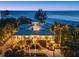 Stunning beachfront home with lush landscaping, palm trees, and breathtaking ocean views at twilight at 26 Sandy Hook S Rd, Sarasota, FL 34242