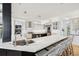 Modern kitchen with a large island, white cabinets, stainless steel appliances, and bar stool seating at 26 Sandy Hook S Rd, Sarasota, FL 34242