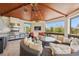 Enclosed lanai with outdoor kitchen, fireplace, comfortable seating, and picturesque views at 26 Sandy Hook S Rd, Sarasota, FL 34242