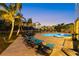 Stunning outdoor pool area featuring lounge chairs, covered seating, tropical foliage, and inviting ambiance at 26 Sandy Hook S Rd, Sarasota, FL 34242