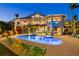 Luxurious home featuring a large, illuminated pool and hot tub with ample seating and a spacious outdoor entertainment area at 26 Sandy Hook S Rd, Sarasota, FL 34242