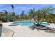 Resort-style pool area with lush landscaping, lounge chairs, and a covered seating area for relaxation at 26 Sandy Hook S Rd, Sarasota, FL 34242