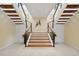 Elegant staircase with wooden steps, glass railings, and stylish decor, creating an inviting entrance at 26 Sandy Hook S Rd, Sarasota, FL 34242