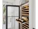 Built-in wine fridge with glass door and wooden shelving, showcasing the wine collection at 26 Sandy Hook S Rd, Sarasota, FL 34242