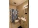 Cozy bathroom with white vanity, toilet, and blue patterned shower curtain at 2624 Hidden Lake Dr N # C, Sarasota, FL 34237