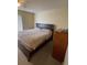 Bedroom with a dark wood frame bed, carpet, and matching wood dresser at 2624 Hidden Lake Dr N # C, Sarasota, FL 34237