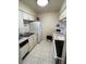 Efficient kitchen layout with white cabinets, appliances, and tile flooring for easy maintenance at 2624 Hidden Lake Dr N # C, Sarasota, FL 34237