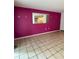 Spacious living room with bright magenta wall and a pass through to the kitchen at 2733 Hidden Lake Blvd # A, Sarasota, FL 34237