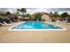 Community pool surrounded by lounge chairs and lush landscaping on an overcast day at 2733 Hidden Lake Blvd # A, Sarasota, FL 34237