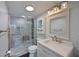 Updated bathroom featuring a glass-enclosed shower, marble surround, and modern vanity with storage at 2901 26Th W St # 312, Bradenton, FL 34205