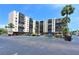 Multi-story condo building with ample parking, balconies, and mature palm trees against a sunny sky at 2901 26Th W St # 312, Bradenton, FL 34205