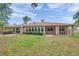Backyard view of a house with a covered patio, large windows, and manicured landscaping, perfect for outdoor living at 3006 Wister Cir, Valrico, FL 33596