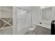 Elegant bathroom with a tub-shower combo, gray vanity, and unique black and white patterned flooring at 3006 Wister Cir, Valrico, FL 33596