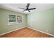 Green-walled bedroom featuring modern ceiling fan, window, and wood-look floors at 3006 Wister Cir, Valrico, FL 33596